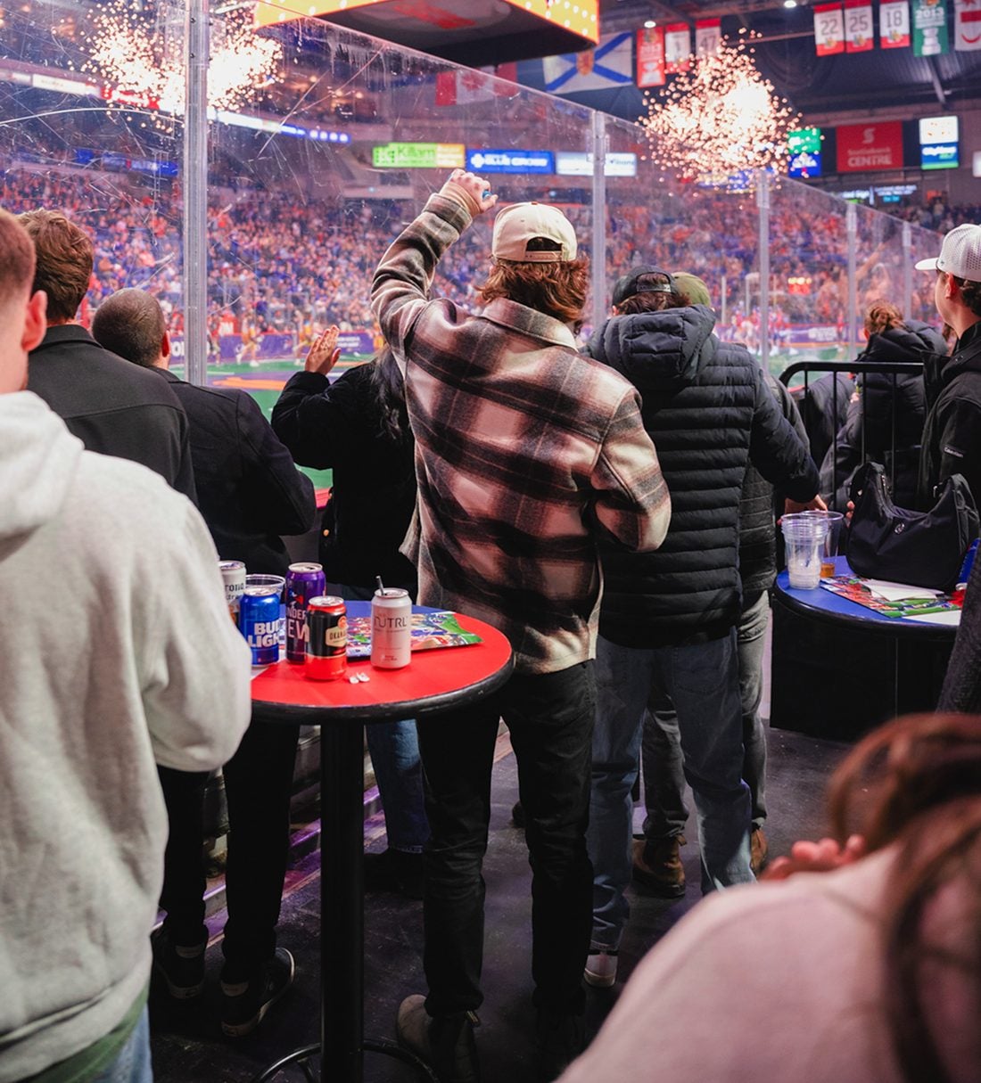 Fans at Party Pit table tops cheering along the glass as fireworks go off